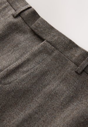 Rudos spalvos skiautinio rašto audinys su lygiu paviršiumi, turintis plokščią liemens juostą ir subtilias klostes priekyje.