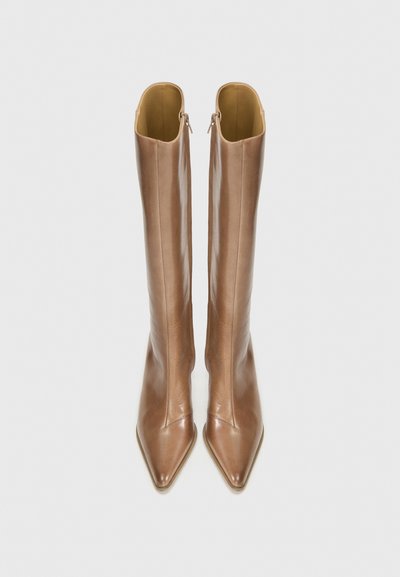 Knee-high, špicaté čižmy z hladkej, svetlohnedej kože s elegantným siluetou a zapínaním na zips vzadu.