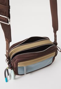 Borsa a spalla marrone con più scomparti con cerniera; realizzata in pelle e tessuto, presenta un sottile accento blu e tracolle texture.