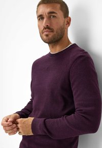 Paarse gebreide trui met geribde manchetten en ronde halslijn, met een gestructureerde afwerking en versterkte schoudernaden.