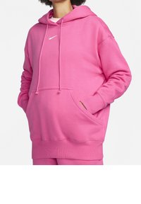 Pink hoodie made from soft fabric with a front pocket, drawstring hood, and a small white Nike logo on the chest. Smooth texture.
