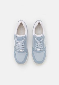 Paire de baskets Tom Tailor bleu clair et blanc avec lacets, vues de dessus sur un fond blanc uni.