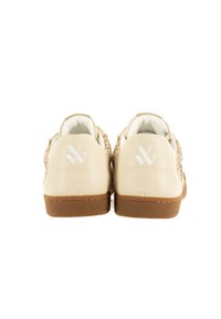 Zapatos de cuero beige con un acabado texturizado y acentos de purpurina dorada, que cuentan con una suela de color claro y un logotipo blanco en el talón.