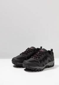 Black hiking shoes with mesh and synthetic upper, textured sole, red accents, padded collar, and lace-up design.