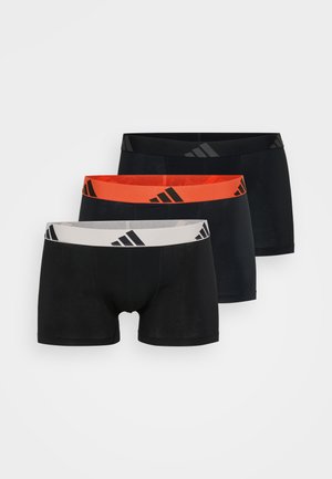 Tres pares de calzoncillos de hombre con una cinturilla negra y tres rayas. Colores: negro, naranja y blanco. Tela suave, diseño ajustado.