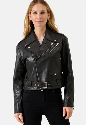 Giacca da moto in pelle nera con design corto, cerniere asimmetriche, colletto a scatto e vita con cintura. Texture liscia con dettagli in argento.