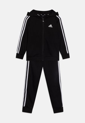 Chándal negro de Adidas que incluye una sudadera con cremallera y pantalones a juego. Detalles de franjas blancas a lo largo de las mangas y las piernas. Textura de tela suave.