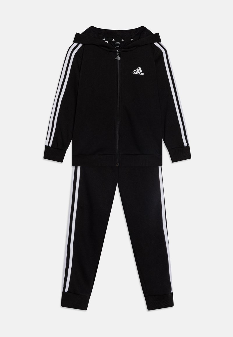 Tuta Adidas nera con cappuccio zip e pantaloni abbinati. Accenti a strisce bianche lungo maniche e gambe. Tessuto morbido.