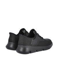 Zapatillas deportivas negras con parte superior de cuero liso, panel trasero texturizado y suela de goma con agujeros de ventilación. Cordones y acentos de marca visibles.