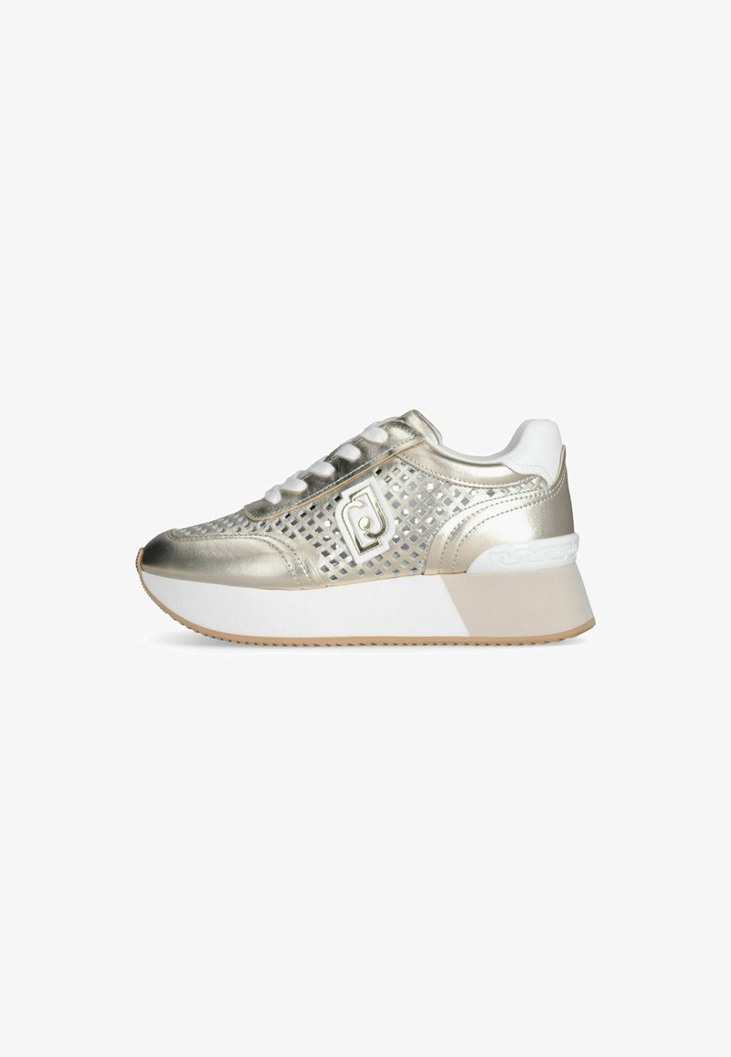 Sneaker metallico oro con design in rete, accenti bianchi, suola bianca spessa e punta arrotondata. Presenta un marchio decorativo sul lato.