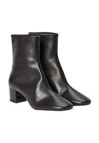 Bottines noires à la cheville avec un design élégant, en cuir lisse. Présentent un bout carré et un petit talon bloc. Fermeture éclair sur le côté.