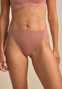 Mauve seamless bra and bikini set, featuring a soft elastic band, smooth texture, and fitted design, emphasizing comfort and minimalistic style.