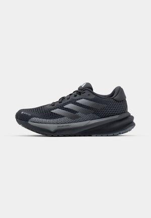 Schwarzer Sportschuh mit einem strukturierten Mesh-Obermaterial, reflektierenden Akzenten, gepolsteter Sohle und einem schlanken Design. Enthält ein Logo mit drei Streifen.