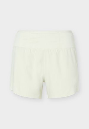 Άσπρα αθλητικά σορτς με ενσωματωμένη εσωτερική επένδυση, φαρδιά ζώνη και χαλαρό, ρευστό εξωτερικό στρώμα.