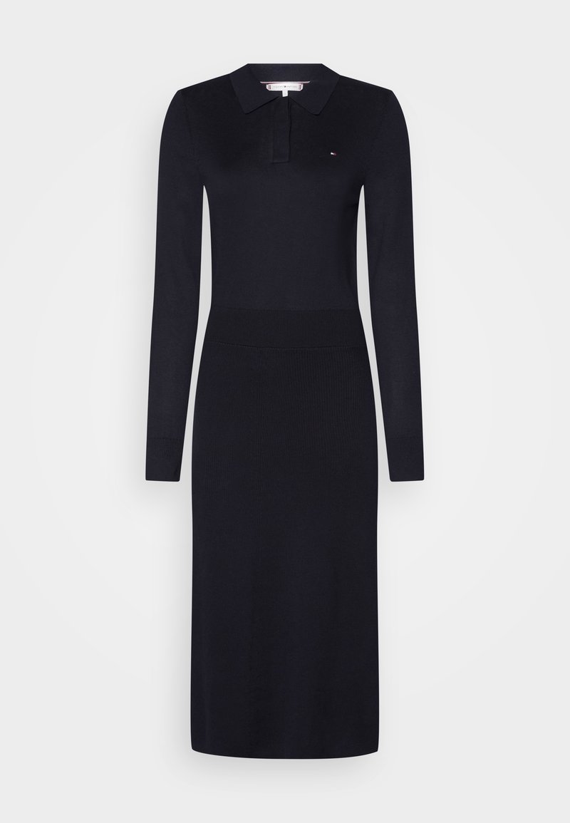 Robe midi noire à manches longues avec col polo, détail côtelé à la taille et petit logo sur la poitrine.