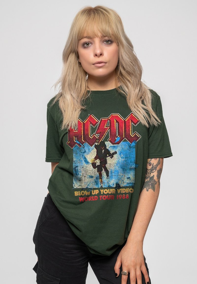 Olive green T-shirt featuring a large AC/DC graphic with a musician, blue background, and "Blow Up Your Video World Tour 1988" text.