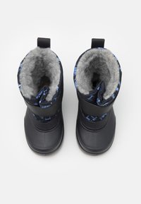 Botas de nieve negras con un suave forro de piel gris, que presentan un upper de tela azul con patrón y correas negras ajustables para un ajuste seguro.