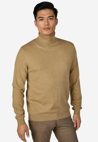 Beiger Rollkragenpullover aus weichem Strickmaterial. Mit langen Ärmeln und figurbetontem Schnitt sowie gerippten Details am Hals- und Ärmelabschluss.
