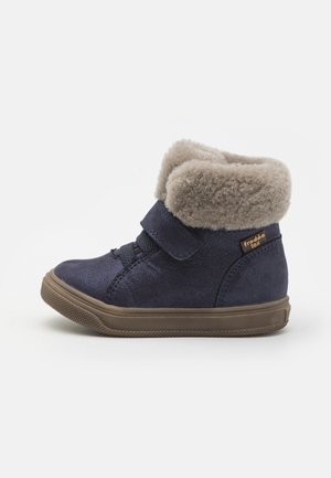 Pantofii sport înalți, de culoare bleumarin, cu o suprafață texturată, guler din blană artificială moale de culoare gri și curea cu arici. Au o talpă din cauciuc cu textură anti-derapantă.