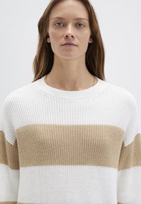 Gestrickter Pullover mit horizontalen Streifen in Weiß und Hellbraun, mit einem weiten Ausschnitt und langen Ärmeln. Strukturierter, leichter Stoff.