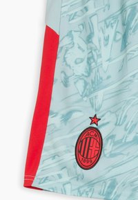 Jersey w kolorze aqua z abstrakcyjnym, jasnoniebieskim wzorem, czerwonymi jednolitymi bocznymi panelami oraz czarnym haftowanym logo AC Milan z gwiazdką na górze.