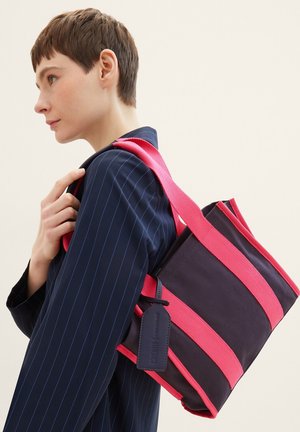 Borsa a spalla in tela blu navy con audaci strisce rosa e finitura texture. Presenta una forma rettangolare e un piccolo cartellino attaccato.