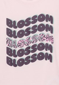 Επαναλαμβανόμενο έντονο κείμενο «BLossom» σε σκούρο μωβ με σκιές τιρκουάζ  σε ανοιχτό ροζ φόντο, μια σειρά με μοτίβο ροζ και μαύρες ρίγες ζέβρας.