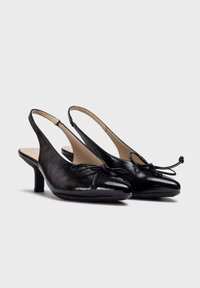 Chaussures slingback en cuir noir avec un bout pointu, une finition texturée, un détail en nœud et un petit talon.