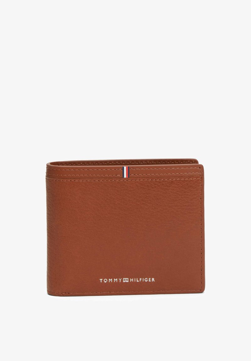 Cartera de cuero marrón con textura suave, diseño plegable y una franja de acento en rojo, blanco y azul en la parte superior. Incluye el logotipo de la marca.