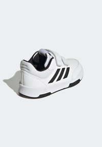 Biały but sportowy z czarnymi akcentami, z chropowatą cholewką, dwoma paskami na rzep i lekką gumową podeszwą.