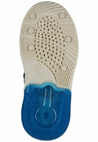 Semelle de chaussure présentant une surface en caoutchouc texturé blanc avec des motifs de grip circulaires, un talon bleu transparent et des marquages de brevet italien.