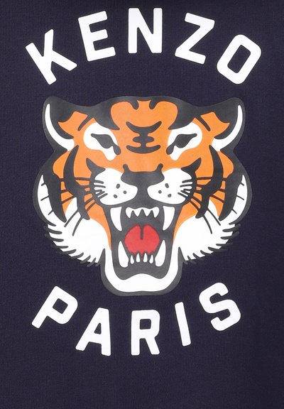 T-shirt marine avec un grand graphisme d'un tigre rugissant en orange et blanc, avec "KENZO" et "PARIS" imprimés en lettres blanches gras en dessous.