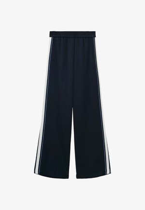 Wijde broek in marineblauw stof met een zachte textuur. Kenmerkt zich door een rekbare tailleband, zijzakken en witte strepen langs de zijkanten.