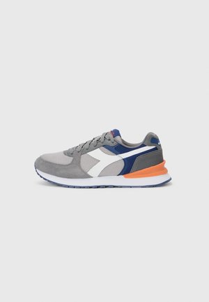 Sport sneakers with a grey mesh upper, suede accents, white and navy details, orange heel, and a textured rubber sole. Lace-up design.