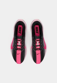 Baskets de sport noires et roses avec une tige en mesh, des bandes contrastantes et une semelle en caoutchouc. Présente le logo Nike sur la languette et les côtés.
