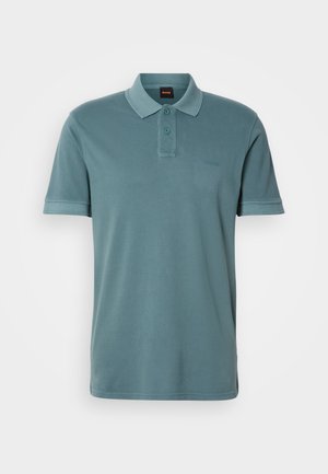 Camisa polo em algodão azul-verde suave com colarinho clássico, mangas curtas, pala com dois botões e discreta bordadura do logotipo no peito.