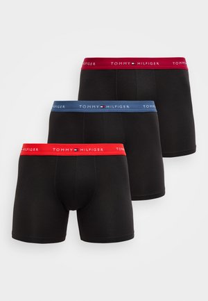 Fekete pamut boxeralsó elasztikus szalagokkal, vörös és kék díszítéssel. A szalagokon a "TOMMY HILFIGER" márkanév látható. Három darabos csomagolás.