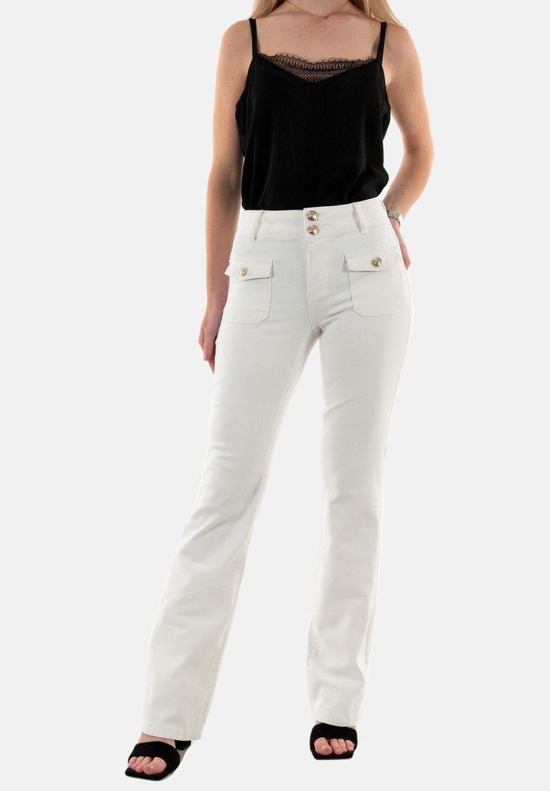 Jean flare blancs avec deux poches avant, accents de boutons dorés et taille ajustée, associés à un débardeur en dentelle noire.