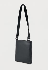 Μαύρη τσάντα χιαστί από λείο δέρμα, με ορθογώνιο σχήμα, ρυθμιζόμενο λουρί και κομψά μεταλλικά διακοσμητικά.