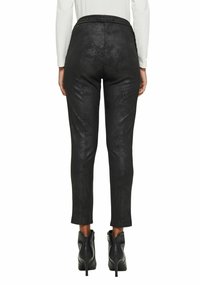 Black faux leather pants with a fitted design, cropped length, smooth texture, and a waistband, paired with ankle-zip heeled boots.