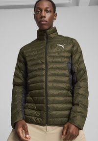 Olivengrøn pufferjakke med sorte sidelommer, horisontal syning, høj krave og en frontlynlås. Har et hvidt Puma-logo på brystet.