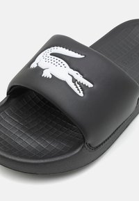 Lacoste SERVE SLIDE JUNIOR SANDALS - Bazénové šmýkačky - black/white