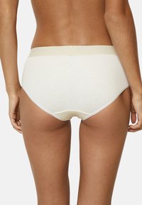 Cream-colored ribbed fabric briefs with a smooth waistband and subtle lace trim along the edges. Positioned from the back view.