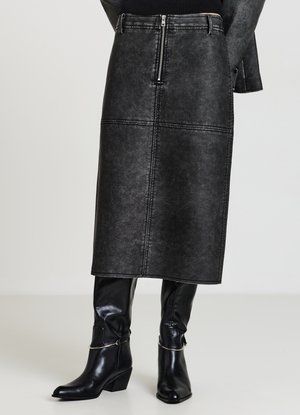 Schwarzer Denim-Midirock mit einem Reißverschluss vorne, vertikalen Nähten und einer glatten Textur. Kombiniert mit kniehohen schwarzen Lederstiefeln.