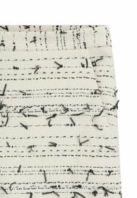 Tissu blanc tissé présentant des lignes texturées noires et des fils noirs éparpillés, créant un motif aux épaisseurs et textures variées.