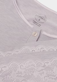 Hellviolettes Oberteil mit rundem Ausschnitt, Einzelknopf, Spitzenbesatz und innenliegendem Etikett mit der Größe S, entworfen in Italien, hergestellt in Bulgarien.