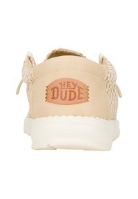 Scarpe slip-on beige con parte superiore in mesh testurizzato e tallone in morbida pelle scamosciata con patch del logo marrone "HEY DUDE". Suola bianca leggera.
