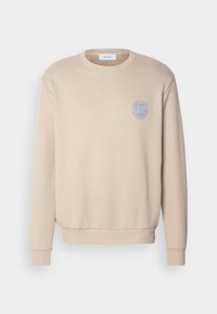 Felpa beige a girocollo con polsini e orlo a costine, che presenta un piccolo logo di un globo blu sulla parte superiore sinistra del petto.