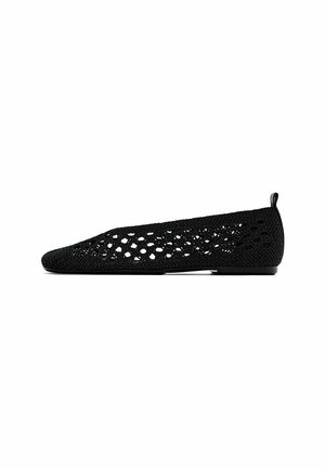 Chaussure plate tissée noire avec un design à treillis ouvert et une petite boucle au talon, vue de côté sur fond blanc.