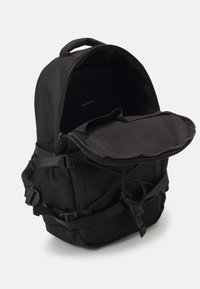Sac à dos noir avec compartiment principal ouvert, bretelles réglables, poches latérales et poche avant en mesh sur fond blanc.